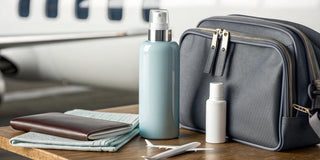 Travel-size moisture conditioner bottles packed in a toiletry bag with a passport.
