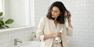 Woman applying a 20-in-1 leave-in treatment for smooth, manageable hair.