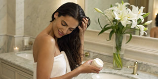 A woman applies daily smoothing cream to her damp hair for a flawless finish.